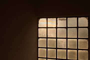 Luz amarela através de esquadria de metal e vidro