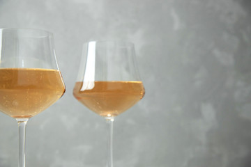 Two glass glasses with orange wine. Close-up. One glass is out of focus. Gray background