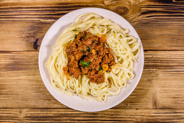 Pasta with bolognese sauce in a ceramic plate. Top view