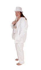 A trumpet player standing in a white outfit and hat in profile