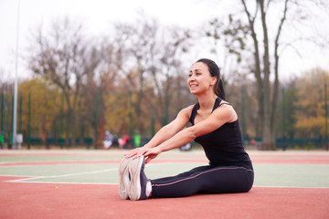 Happy girl doing fitness exercises outdoor on playground. Healthy lifestyle. Morning workout positive emotion smiling sportive people