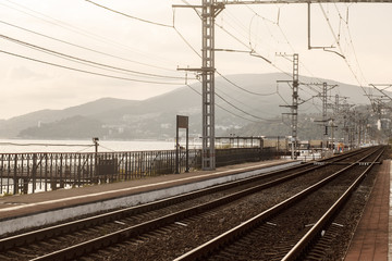 Fototapeta premium Empty railway with no train and people,selective focus and vintage style. Industrial concept background. Railroad travel, railway tourism. Transportation. Tourism day.