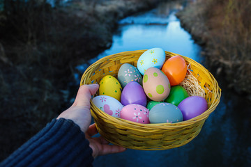 Bild von bunten Ostereiern in einem Korb und mir Fluss Hintergrund