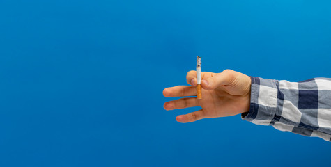 global reason of human death - person hand holding a burning cigarette and smoking isolated on color background