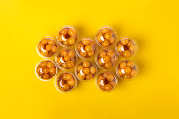 top view of many plastic cocktail packages of orange cherry tomatoes  flat lay on the table