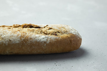 whole grain baguette on a gray concrete background. Close-up