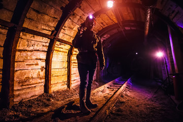 Obraz na płótnie Canvas Miner working a jackhammer in a coal mine. Work in a coal mine. Portrait of a miner. Copy space.
