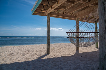 Hammock sitting on beach by the ocean on tropical island