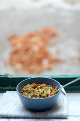 Bowl of stir fry rice with vegetables and eggs, on a rustic window sill. Selective focus.