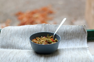 Bowl of stir fry rice with vegetables and eggs, on a rustic window sill. Selective focus.