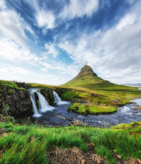 Kirkjufell. Berge und Wasserfall im Island. Naturlandschaft im Sommer. Gras und Fluss. Berühmter Platz. Islandreise - Bild