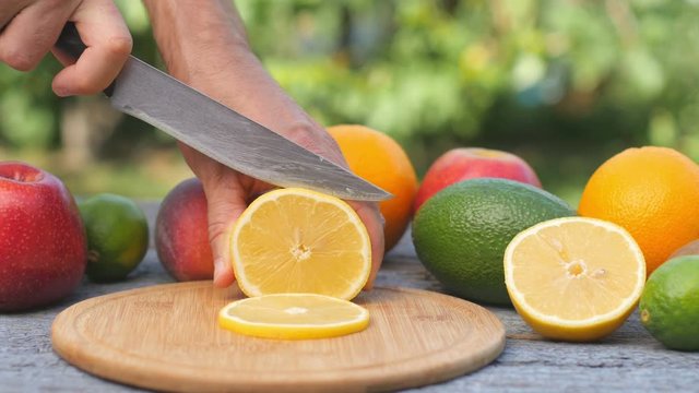 Ripe lemon is ripened on a cutting board. Fresh fruits on the table. Juicy lem cut into slices. Avocado Lemon and apple on the background.