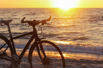 Cycling along the sea coast. Bicycle at sunset.