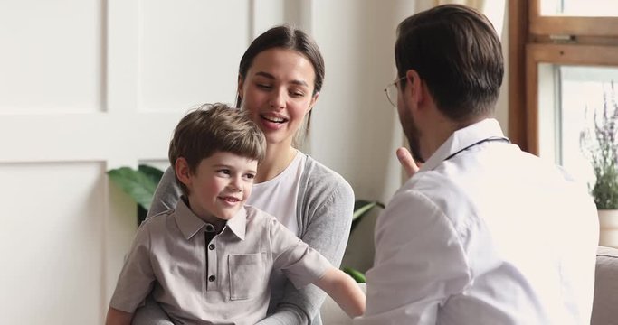 Happy healthy boy give high five to male surgeon doctor