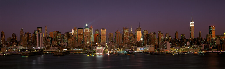 This is Midtown Manhattan and the East River at dusk. It is the view from Hoboken, New Jersey. The Empire State Building is on the right hand side, the Chrysler Building just right of center.