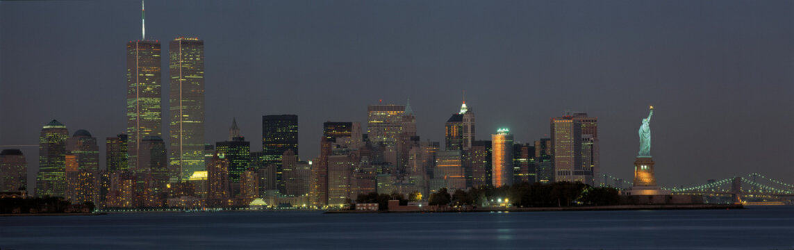 This is the downtown Manhattan skyline and Statue of Liberty. It is the view from New Jersey at dusk. The World Trade towers dominate the left hand side, the Statue of Liberty is on the right.