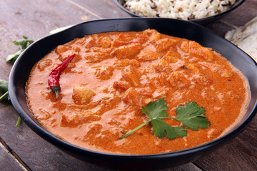 Chicken tikka masala spicy curry meat food in pot with rice and naan bread. indian food