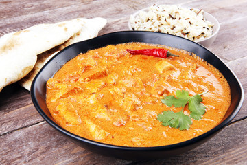 Chicken tikka masala spicy curry meat food in pot with rice and naan bread. indian food