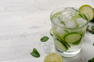 Infused water on a glass. Detox water mix of cucumber, lemon, lime and mint.
