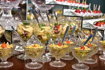 small portions of food pasta, salad, olive oil, spices in glass cups with blurs in the photo