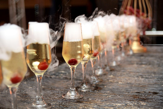 crystal glasses with sparkling cherry and dry ice with blurs and noise