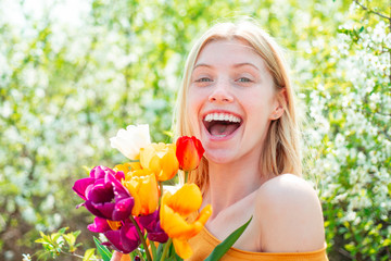 Happy woman relaxing in the tulip fields. Womens day, 8 march. Field of colorful bright red tulips.