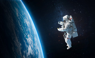 Astronaut in the outer space over the planet Earth. Abstract wallpaper. Spaceman. Elements of this...