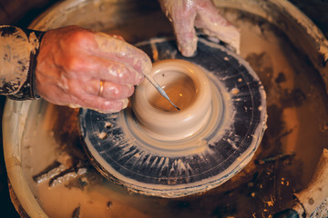 The master forms a clay cup on a potter's wheel. A potter's hands preparing a clay pot. Close-up.