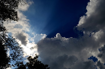 Obraz na płótnie Canvas Sun rays illuminating blue sky. Behind the clouds the sky is always blue.