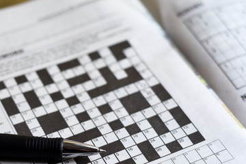 Crossword puzzle from newspaper with a pen to fill in answers