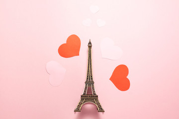Fototapeta na wymiar The Eiffel Tower, two red and two pink hearts on pink background. Flat lay top view of important sights of Paris. Romantic, love, Valentines day and travellings concept