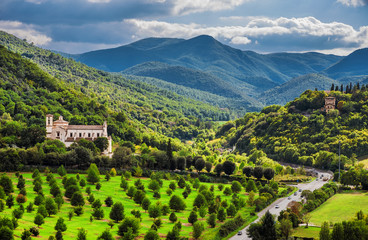 View of the green and beautiful Umbria countryside with the St Peter Extra Moenia ancient church from the city of Spoleto - obrazy, fototapety, plakaty