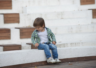 The boy is sitting on a white border. Blurred image - 316641252