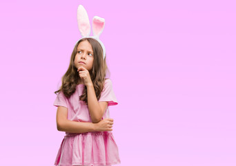 Obraz na płótnie Canvas Brunette hispanic girl wearing easter rabbit ears serious face thinking about question, very confused idea
