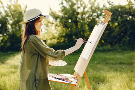 Woman in a summer field. Cute lady drawing. Girl with colorful paints