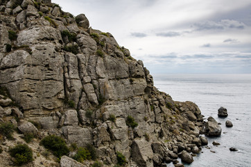 Fototapeta na wymiar Mountain seascape. Large textured rock on the sea coast. Travel and adventure.