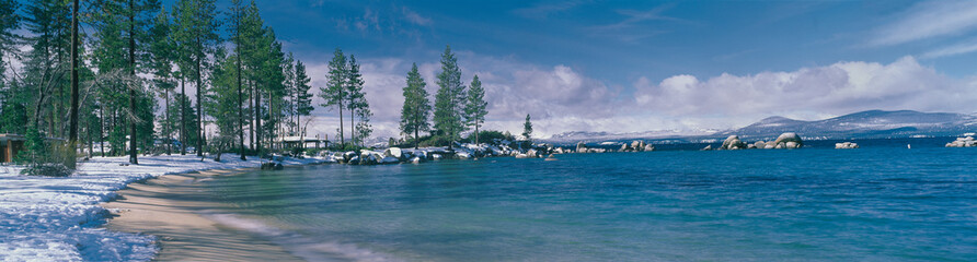 This is the sandy beach at Lake Tahoe. It shows the turquoise water in the winter after a snow storm.