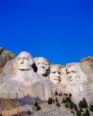 Obraz premium This is a vertical image of Mount Rushmore National Monument showing the four faces of George Washington, Thomas Jefferson, Theodore Roosevelt, and Abraham Lincoln.