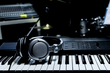 Piano keyboard with headphones for music, Headphones on piano keyboard, close up,headphones on...