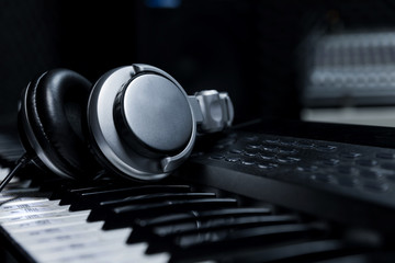 Piano keyboard with headphones for music, Headphones on piano keyboard, close up,headphones on...