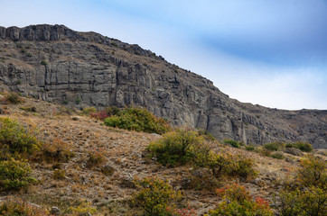 Fototapeta na wymiar Mountain landscape. Sheer cliff and sky. Travel and adventure.