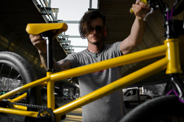 Closeup of hipster man holding BMX trick bike 