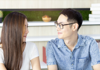 Beautiful young couple bonding and smiling eyes while sitting in the home, happy valentine day.