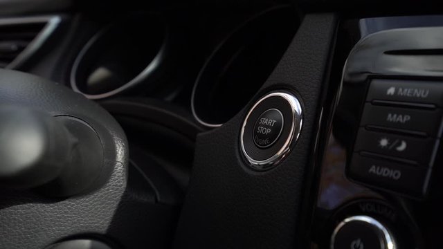Men hand pushing on the start button of a suv car