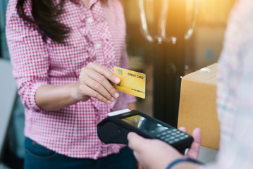 Hand of customer paying with contactless credit card with NFC technology.