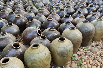 Fototapeta na wymiar Group of ancient terracotta jars on the floor, Vintage clay jar of culture and local life in Southeast Asia, Cambodia
