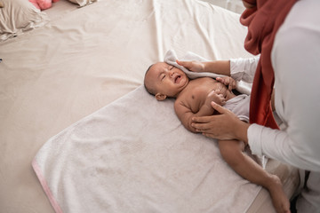 Obraz na płótnie Canvas mother wipe her baby boy with a towel after bath