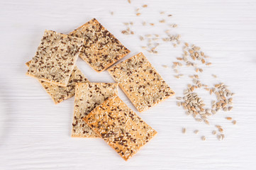 Stack of crispy wheat cakes with sesame, flax and sunflower seeds on white wooden background. Top view. vegetarian food, eco food concepts