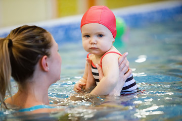 Female and child swim in water pool.
