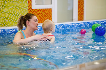 Female and child swim in water pool.